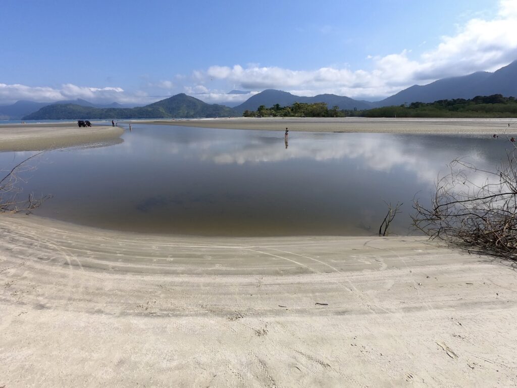 Lagoa ou rio de água doce em Ubatumirim com a praia e as montanhas ao fundo